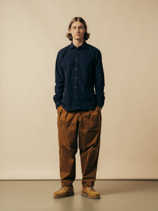 A model wearing a blue corduroy shirt and relaxed fit pants from KESTIN.
