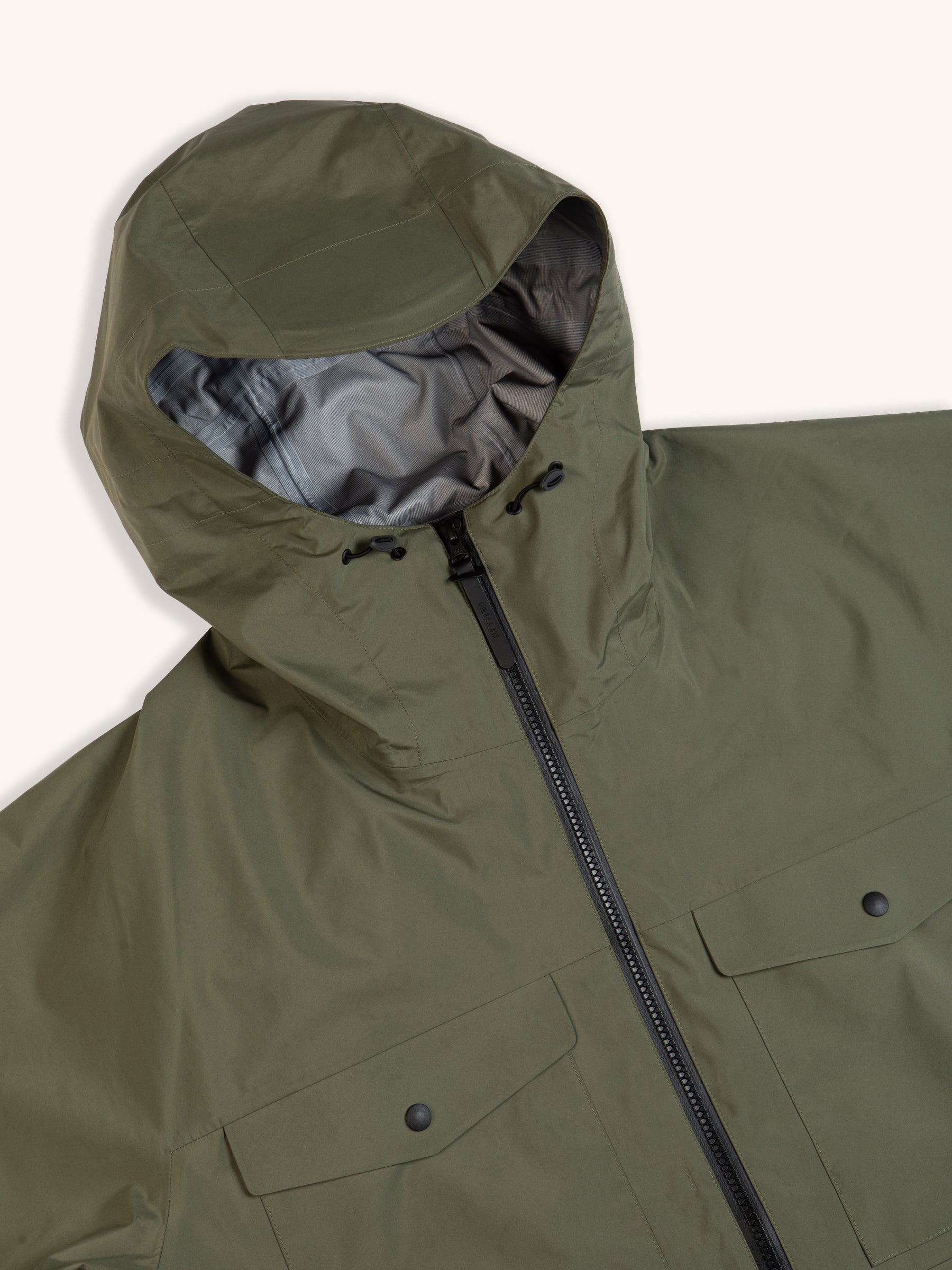 The hood of a green waterproof jacket on a white background.