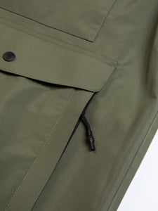 A patch pocket and zippered handwarmer pocket on a waterproof shell jacket.