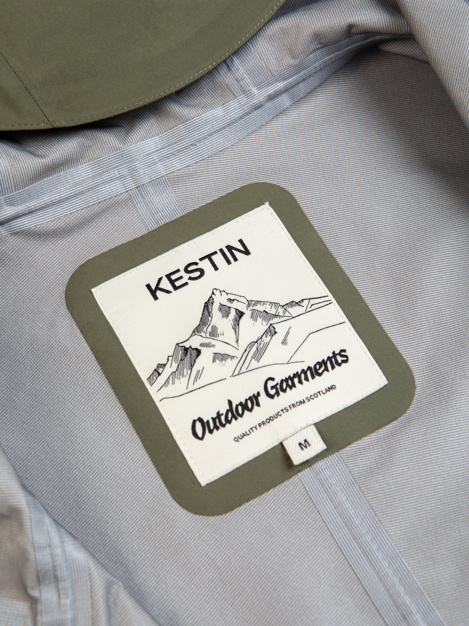 A KESTIN Outdoor Garments logo patch on a men's waterproof jacket.