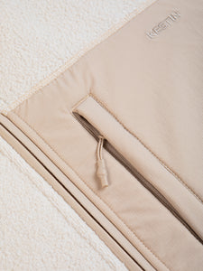 A men's fleece jacket material in an ecru white with a zippered pocket.
