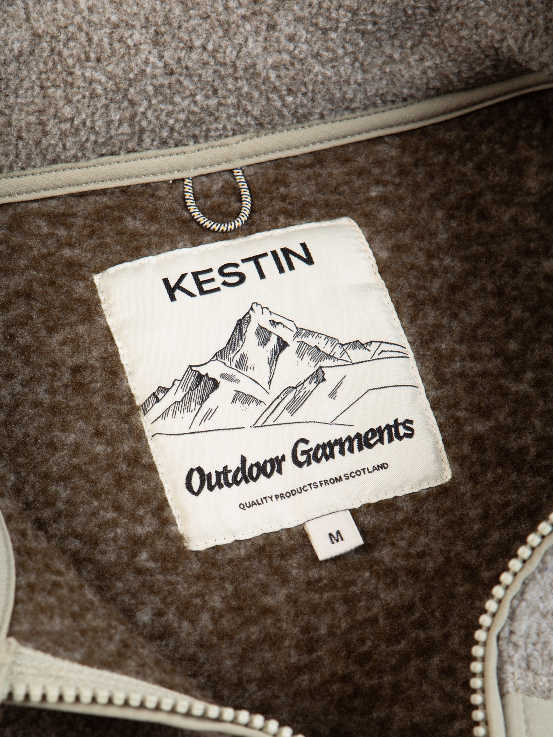 A KESTIN Outdoor Garments neck label sewn to a recycled fleece material.