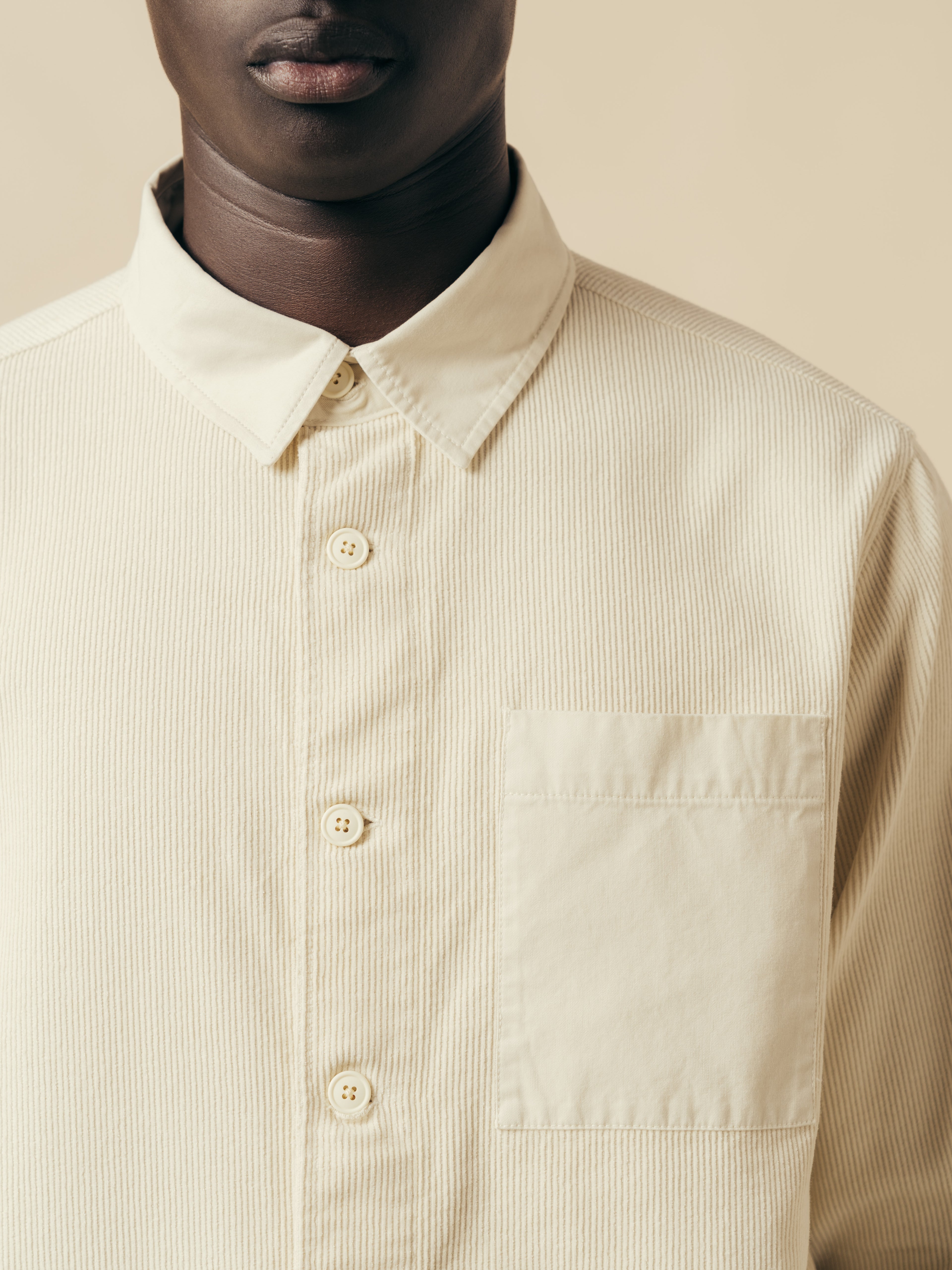 The collar and chest pocket of the KESTIN Rosyth Overshirt in off white.