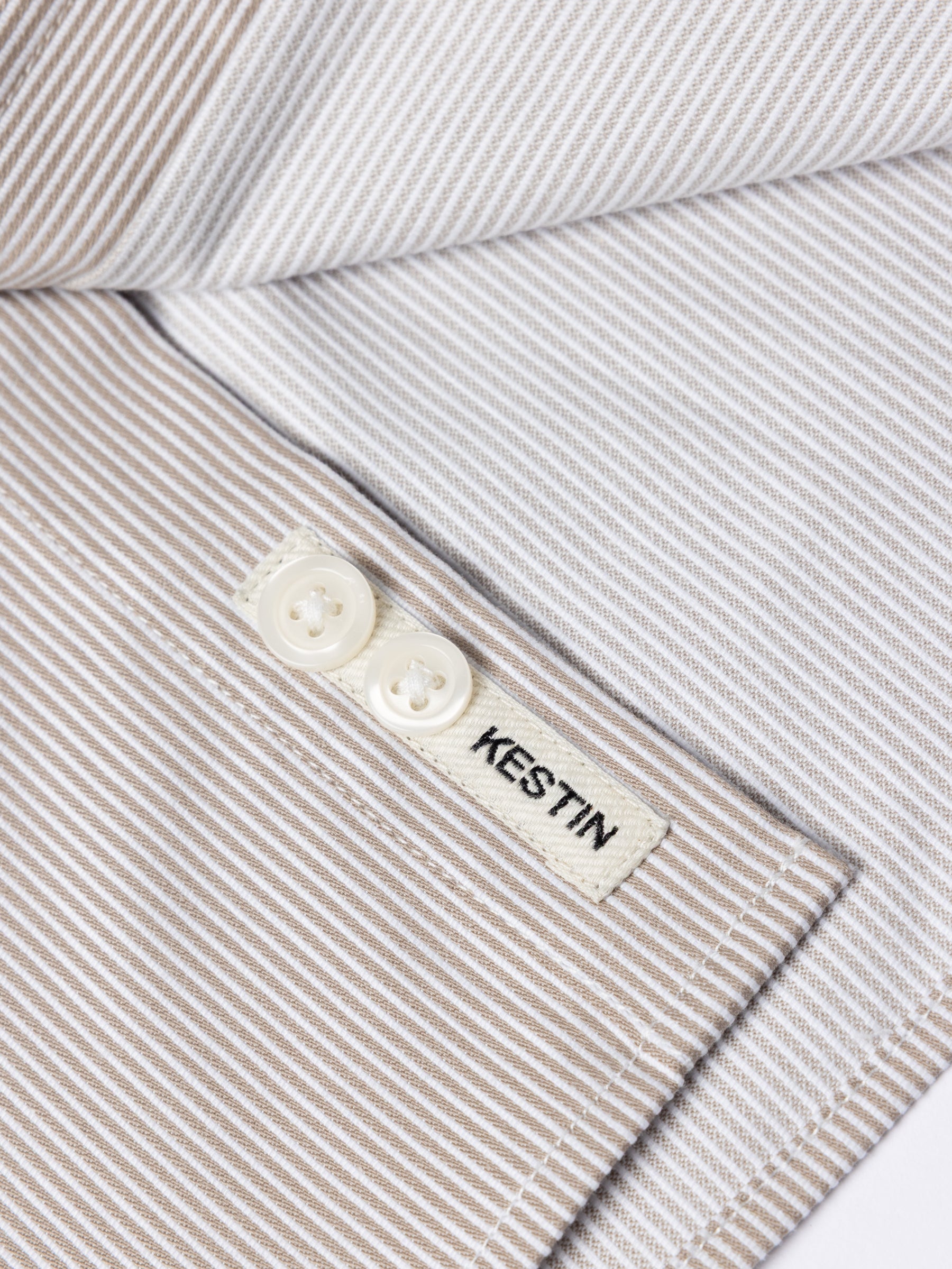 A close-up of the logo patch, sewn to the placket of the KESTIN Raeburn Button Down Shirt.