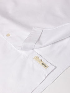 A close-up of the woven logo patch to the hem of the KESTIN Dirleton Shirt.
