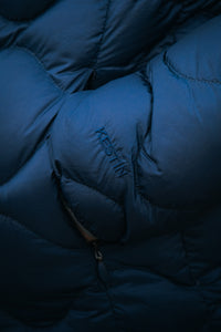 A hand in the pocket of the KESTIN Cuillin Down Jacket in Petrol Blue.