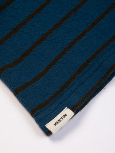 A woven flag label sewn to the hem of a jersey from KESTIN.