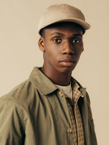 A model wearing a cap, shirt and jacket from menswear brand KESTIN.