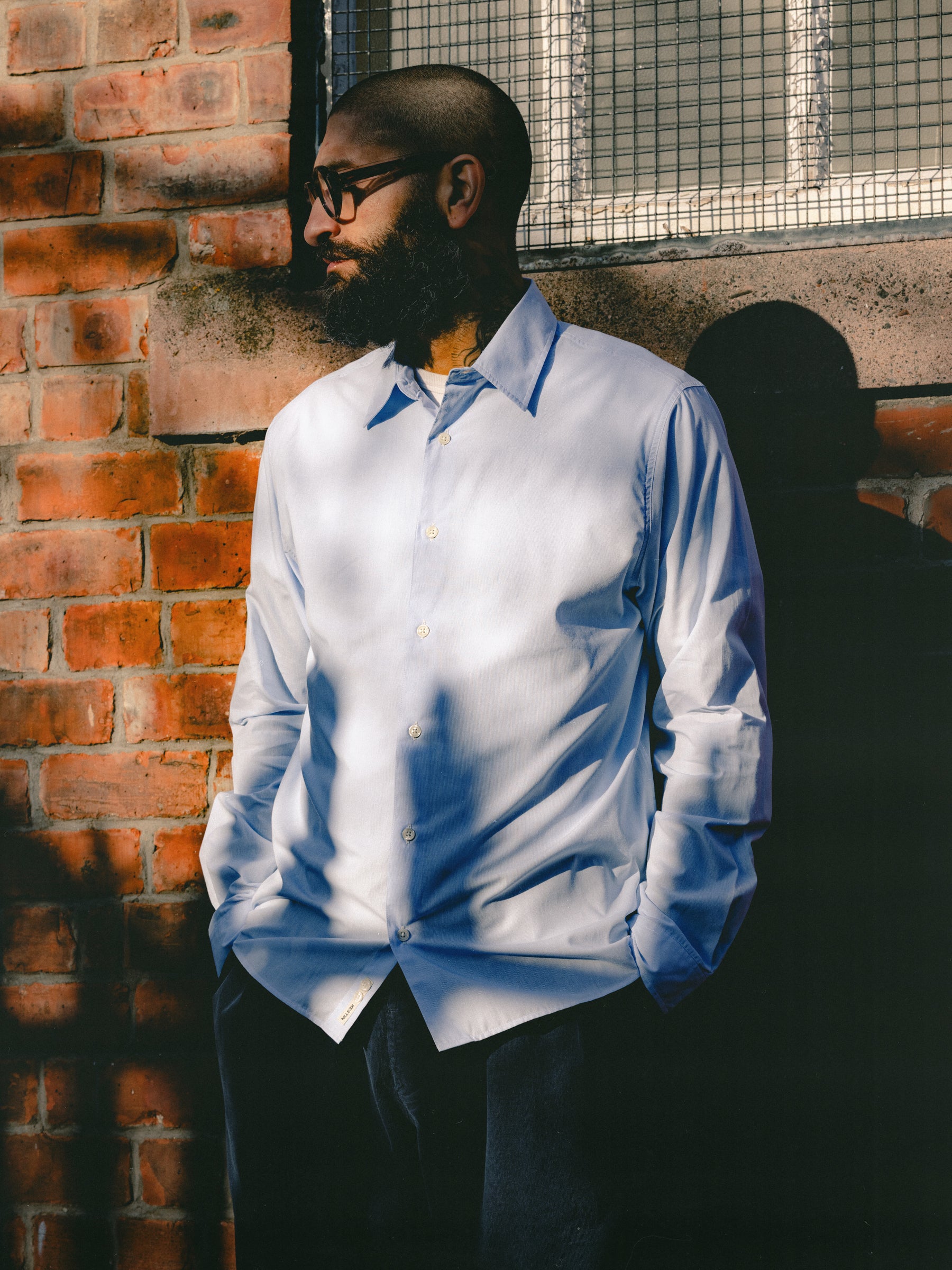A man wearing a blue dress shirt from designer menswear brand KESTIN.