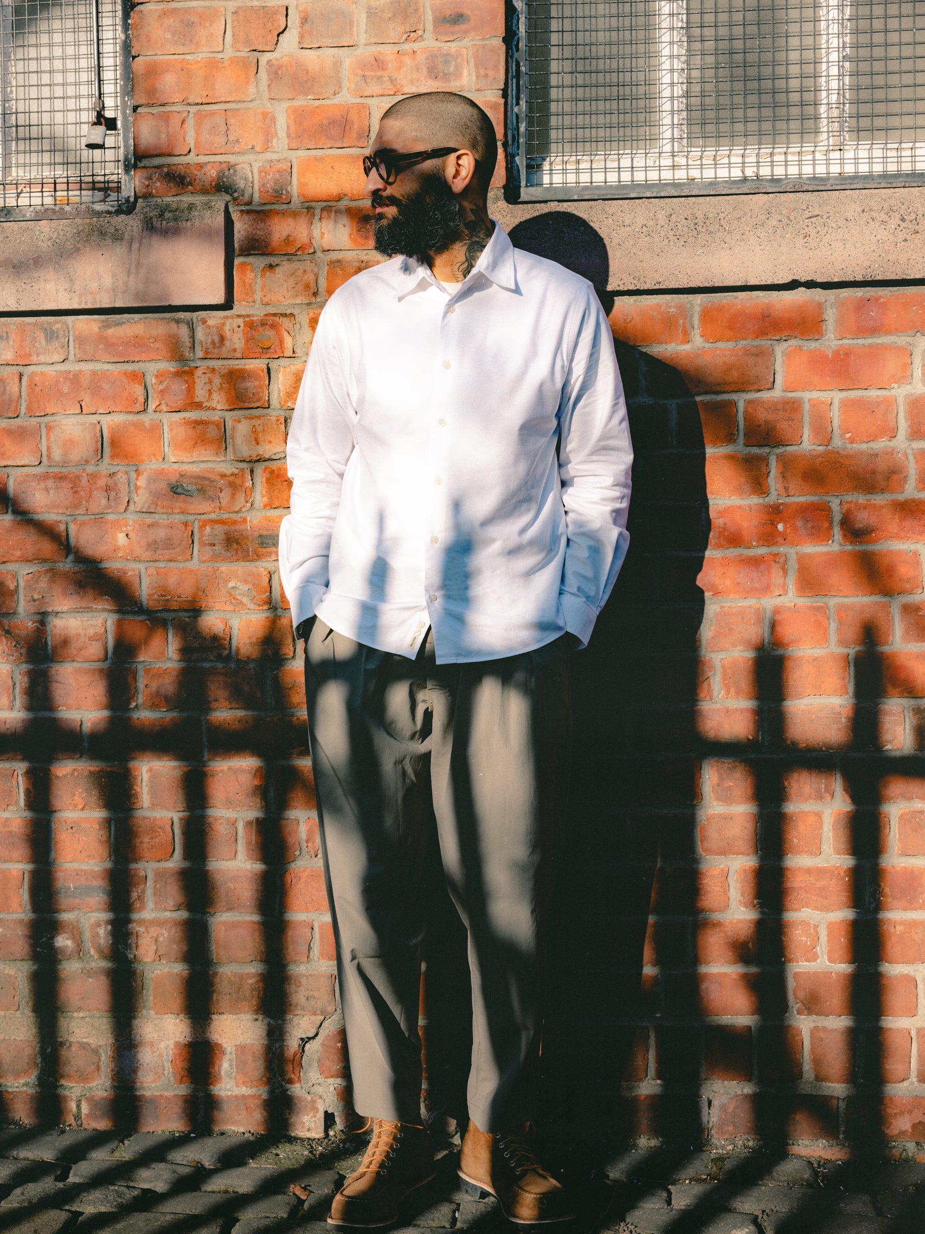 A man standing in the sunshine, wearing classic menswear pieces from designer brand KESTIN.