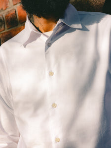 A close-up of the KESTIN Dirleton Shirt in a classic white oxford fabric, with the top button undone.