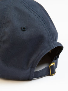 A navy blue six panel cap by KESTIN, close-up on the adjustable strap to the rear.