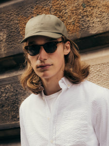 A model wearing an embroidered logo dad cap by Scottish menswear brand KESTIN.