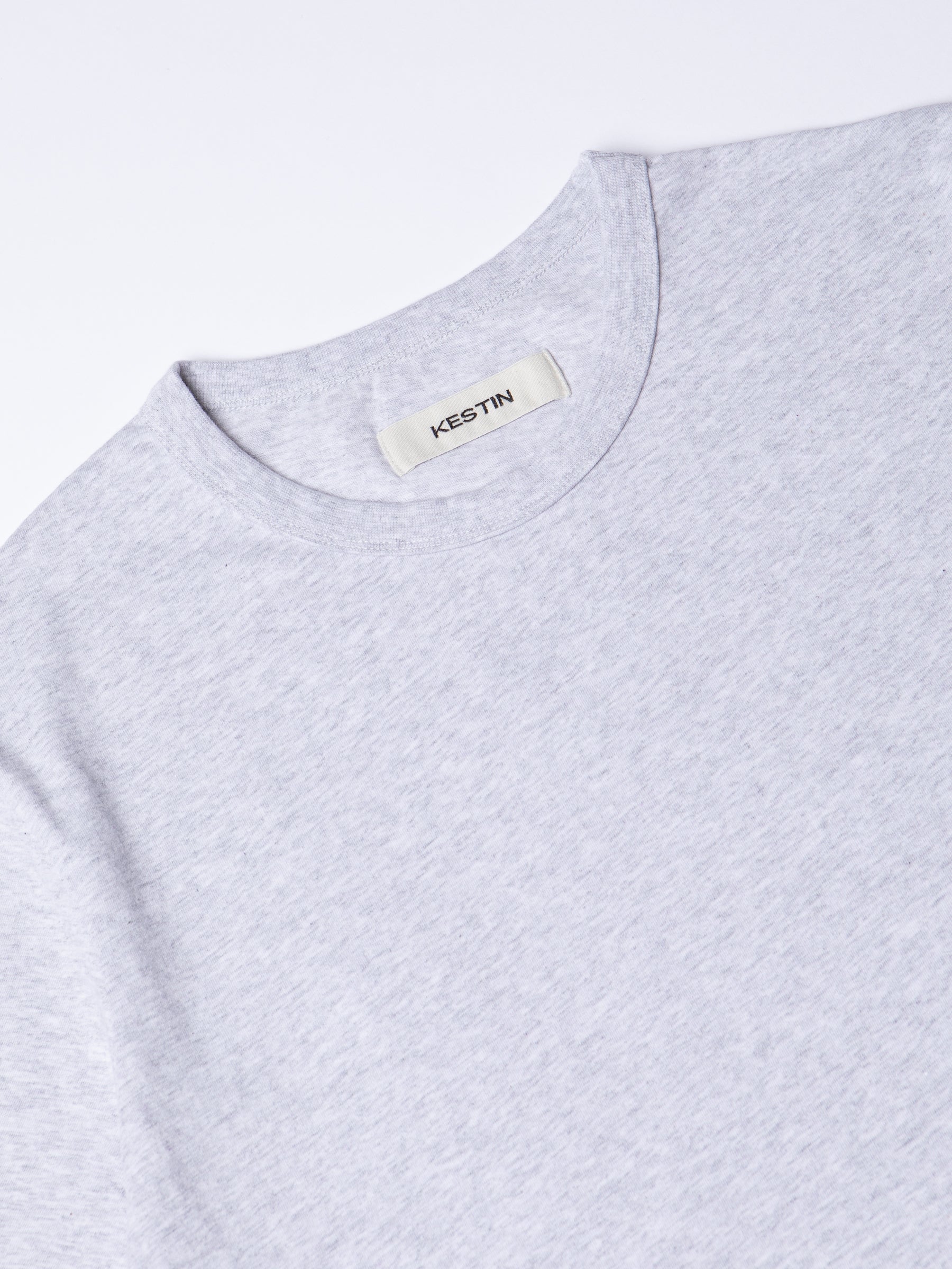 A close-up of the collar of the KESTIN Drem Tee in Grey Marl.
