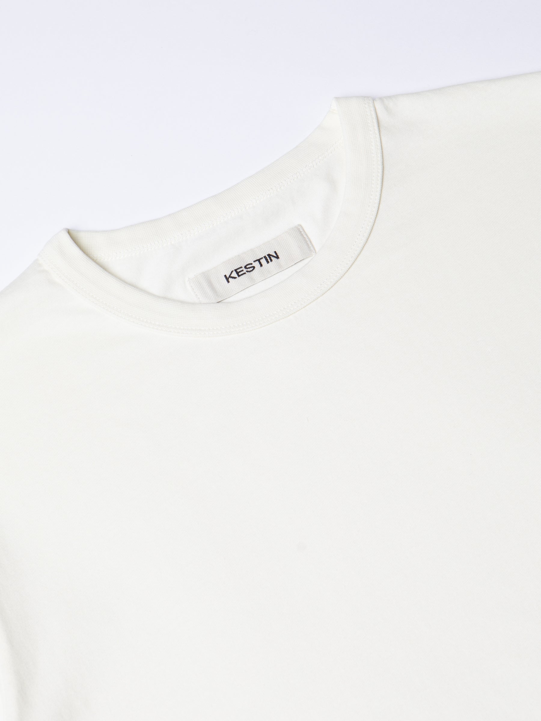 A close-up of the ribbed crew neck and neck label from the KESTIN Drem Tee.