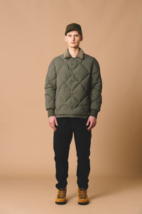 A man wearing a heritage insulated jacket from KESTIN, with a quilted design.