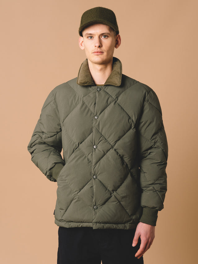 A model wearing the KESTIN Dunbar Down Jacket, which uses recycled synthetic insulation.
