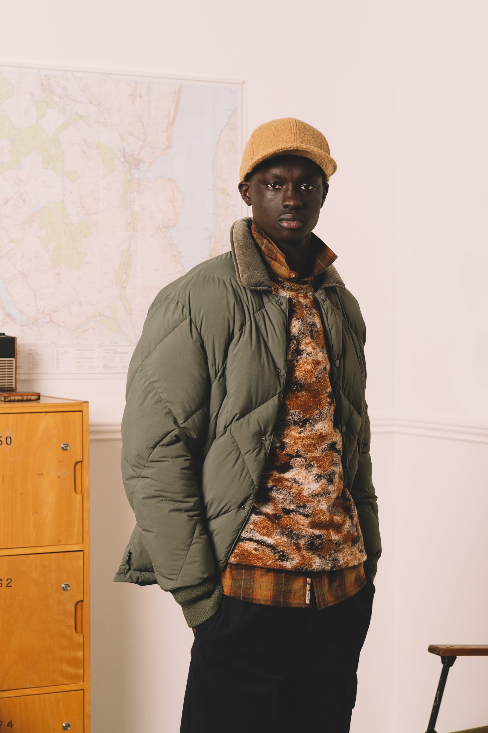 A man wearing casual winter layers, with a flannel shirt, fleece and insulated jacket.