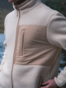 A man wearing a cream white fleece jacket by premium clothing brand KESTIN.