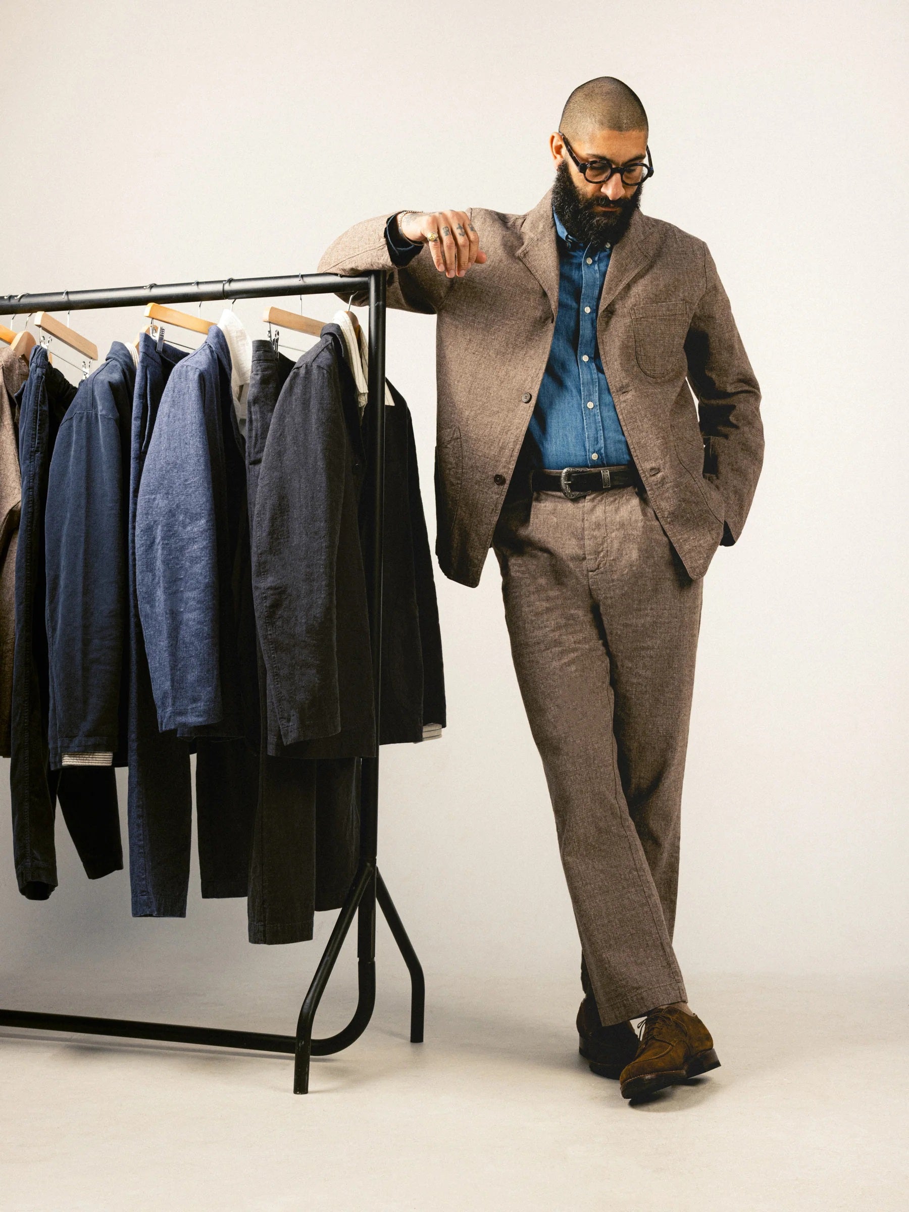 Menswear stylist Leon Cerrone wearing a brown suit and a denim shirt from KESTIN.