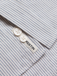 A woven KESTIN logo patch to the placket of a men's oxford shirt.