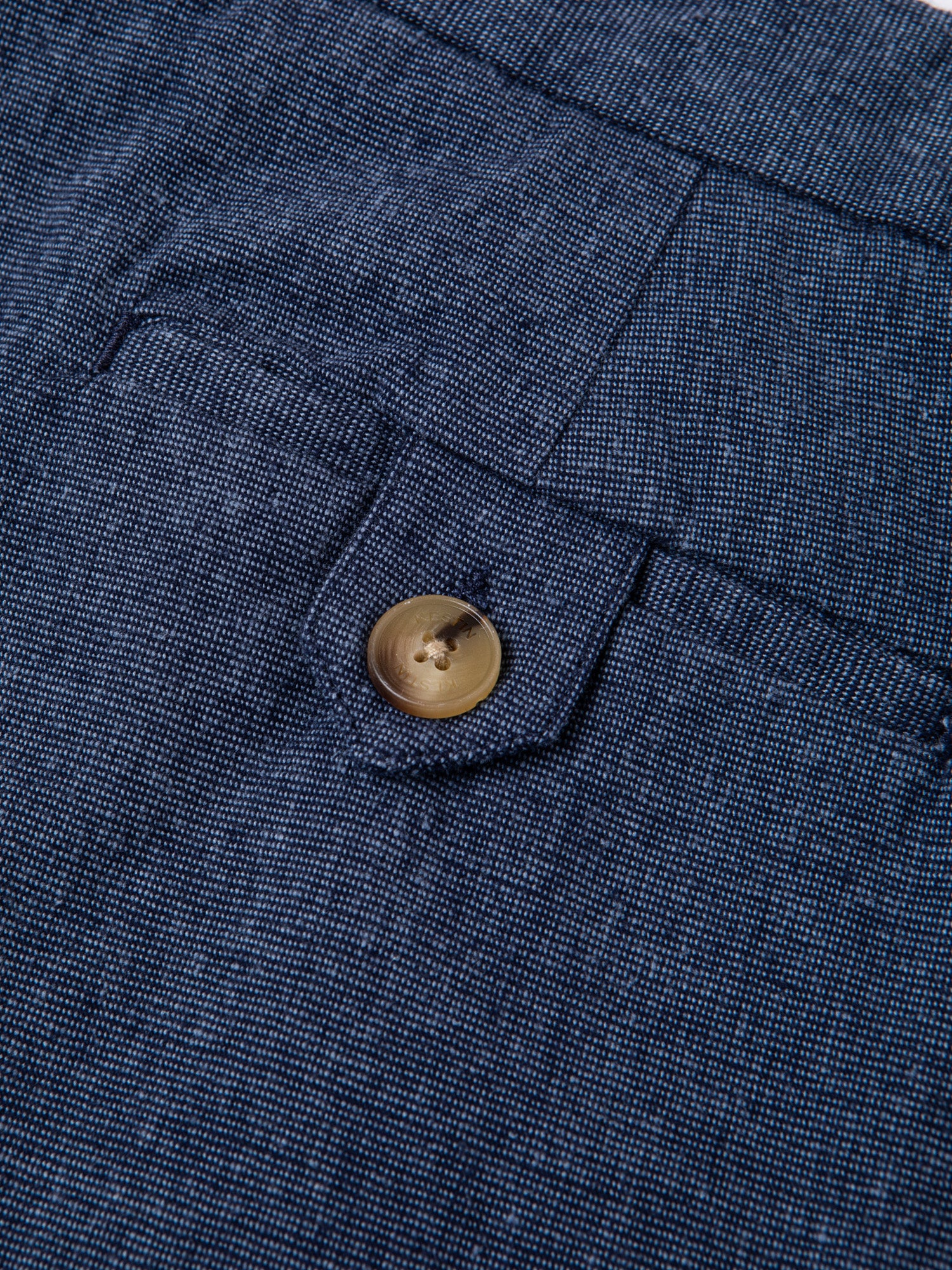 The buttoned rear pocket of the KESTIN Wick Suit Trouser in a blue linen blend.