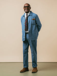 A man smiling whilst wearing a blue suit by premium menswear designer KESTIN.