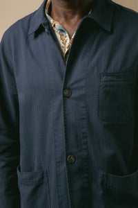 A close-up of the front of the Huntly Jacket from menswear brand KESTIN, with a floral shirt underneath.