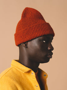 A knitted beanie from contemporary menswear label KESTIN, in a rust red.