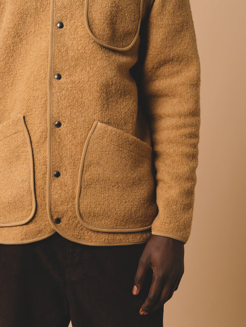 A wool fleece with a snap-up front and three patch pockets in a tan brown, worn on a model.