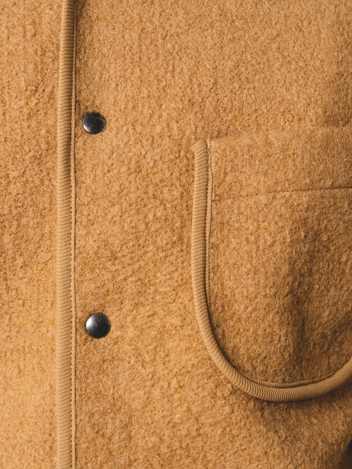 A close-up of a men's wool fleece with a pocket and snap-up front.