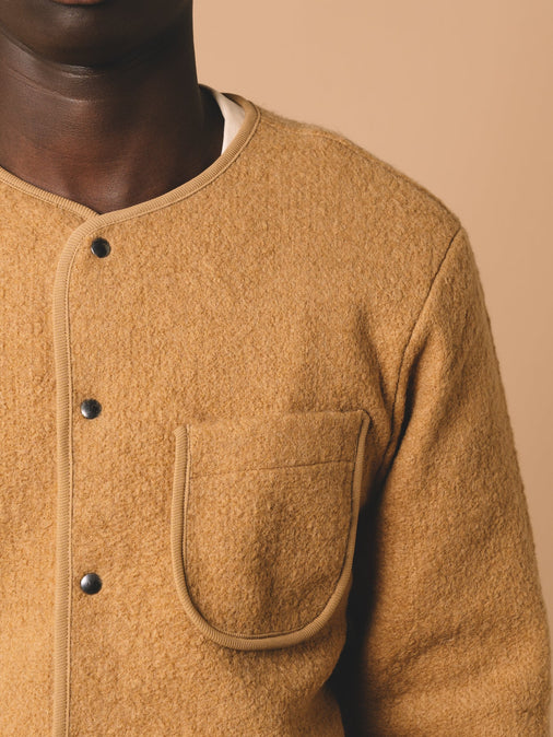 A patch chest pocket to a warm wool cardigan, worn on a model.