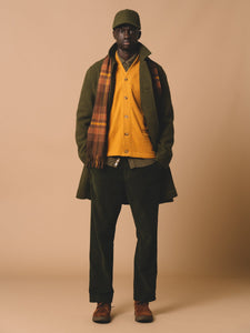 A model wearing a layered winter outfit, with knitwear, corduroy and fleece.