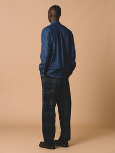 This model is facing away to show the back of the Dirleton Shirt by British designer brand KESTIN, which is made from a comfortable cotton denim.