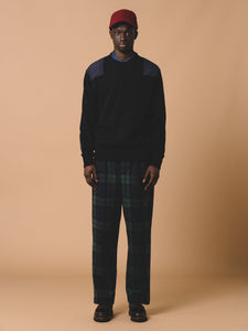 A model wearing a navy knitted sweater by contemporary menswear label KESTIN.