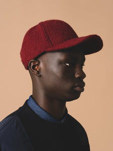 A model wearing the Comets Cap in Burgundy Red by Scottish menswear brand KESTIN.