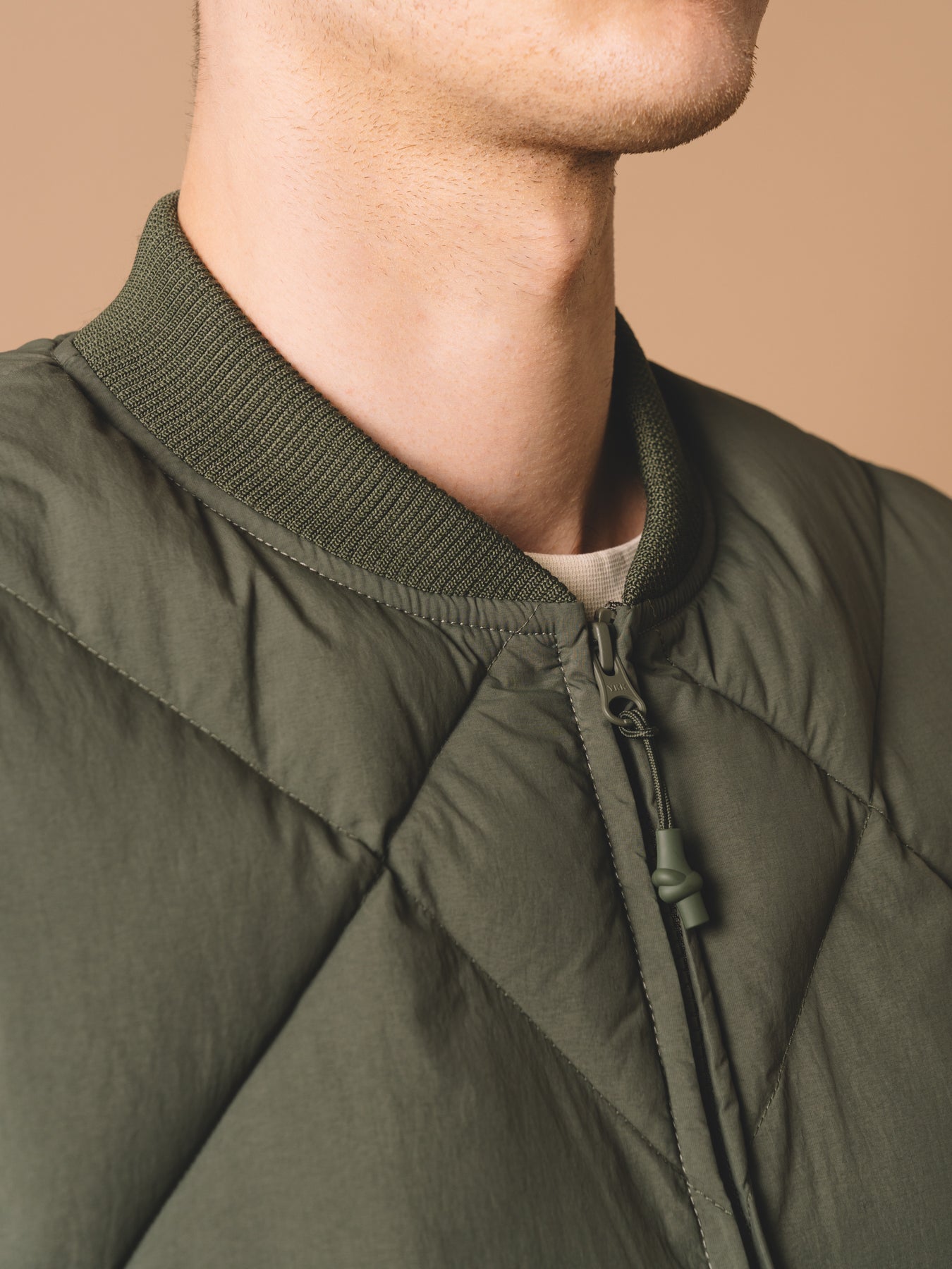 An insulated gilet with a ribbed collar and a zipper to the front.