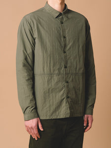 A model wearing the Armadale Overshirt from KESTIN, in a technical green nylon from Italy.