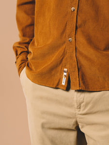 A woven logo patch from Scottish menswear designer KESTIN, sewn to the front of the Dirleton Shirt which is made from Cotton Corduroy in a medium Tobacco Brown colour.