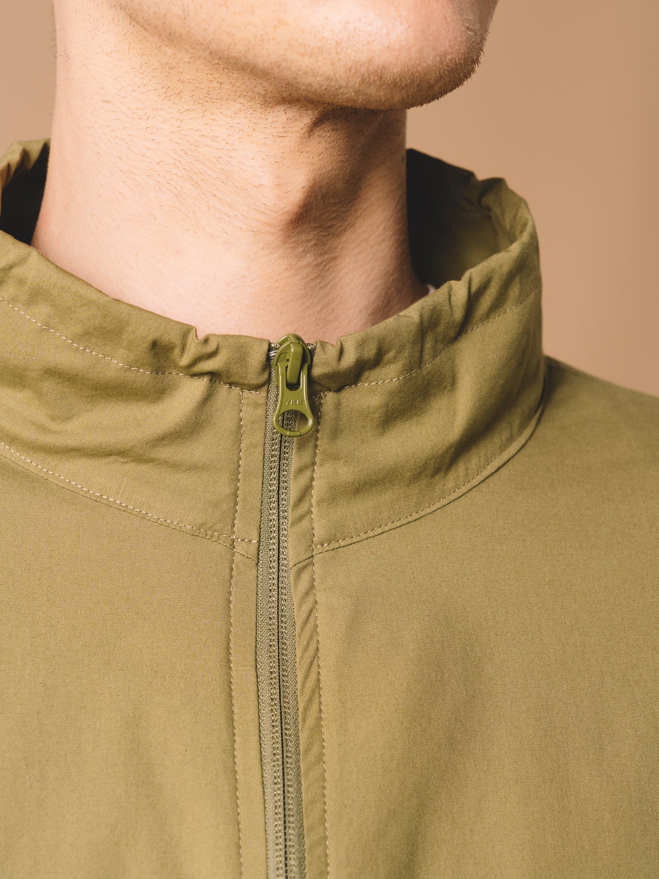 A zippered neck from the KESTIN Crieff Windbreaker in Military Green.