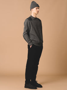 A model wearing the Cupar Nato Knit by menswear designer KESTIN, styled with a beanie, tapered trousers and boots.
