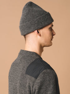 A model wearing premium men's knitwear, with a Scottish wool beanie and Japanese wool sweater.