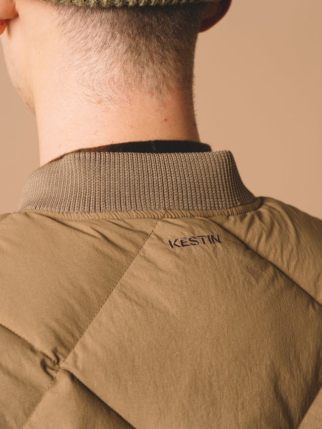 A close-up of the back of the KESTIN Linton Vest, with an embroidered logo from the Scottish menswear brand.