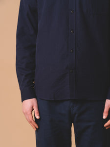 The buttoned placket from a KESTIN Raeburn Shirt, worn on a model in a Navy Blue colourway.