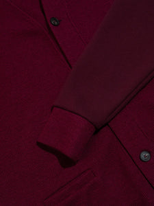 The ribbed cuff from a designer men's cardigan in a dark red colour.