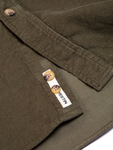 The placket of the KESTIN Dirleton Shirt in Olive Green Corduroy, featuring a woven logo patch.