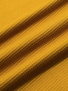 A yellow waffle material, made from a lightweight 100% cotton, used to make the KESTIN Fly Tee.