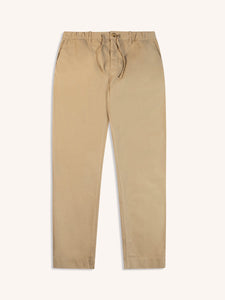 A pair of men's slim tapered fit trousers, in stone tan on a white background.
