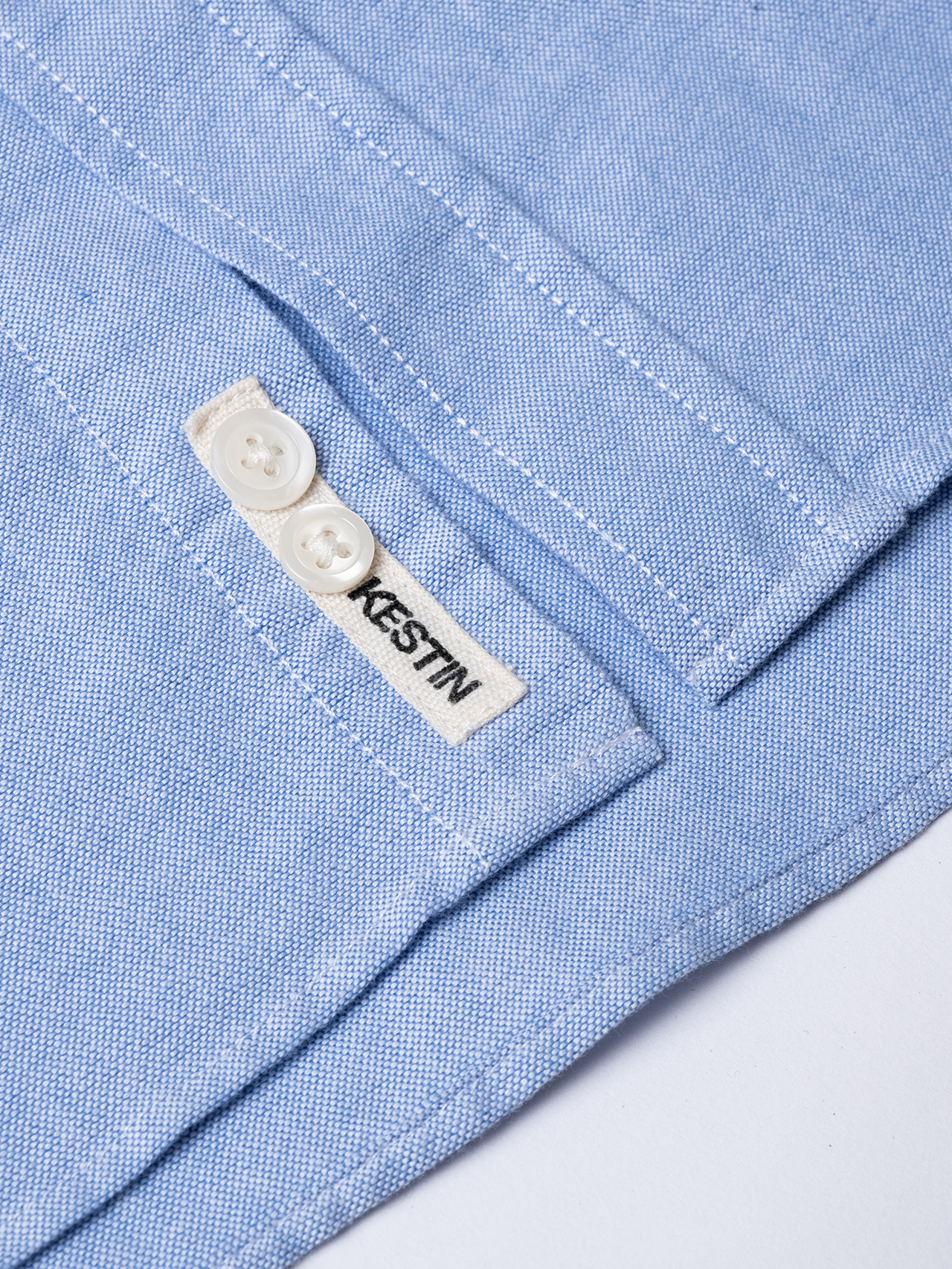 A close up of a classic men's Oxford Shirt, designed by menswear brand KESTIN, with a woven logo patch to the placket.
