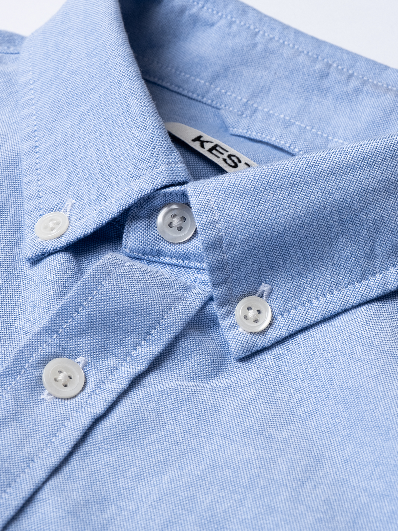The buttoned collar of a classic men's Oxford Shirt, designed by premium menswear brand KESTIN, based in Scotland.